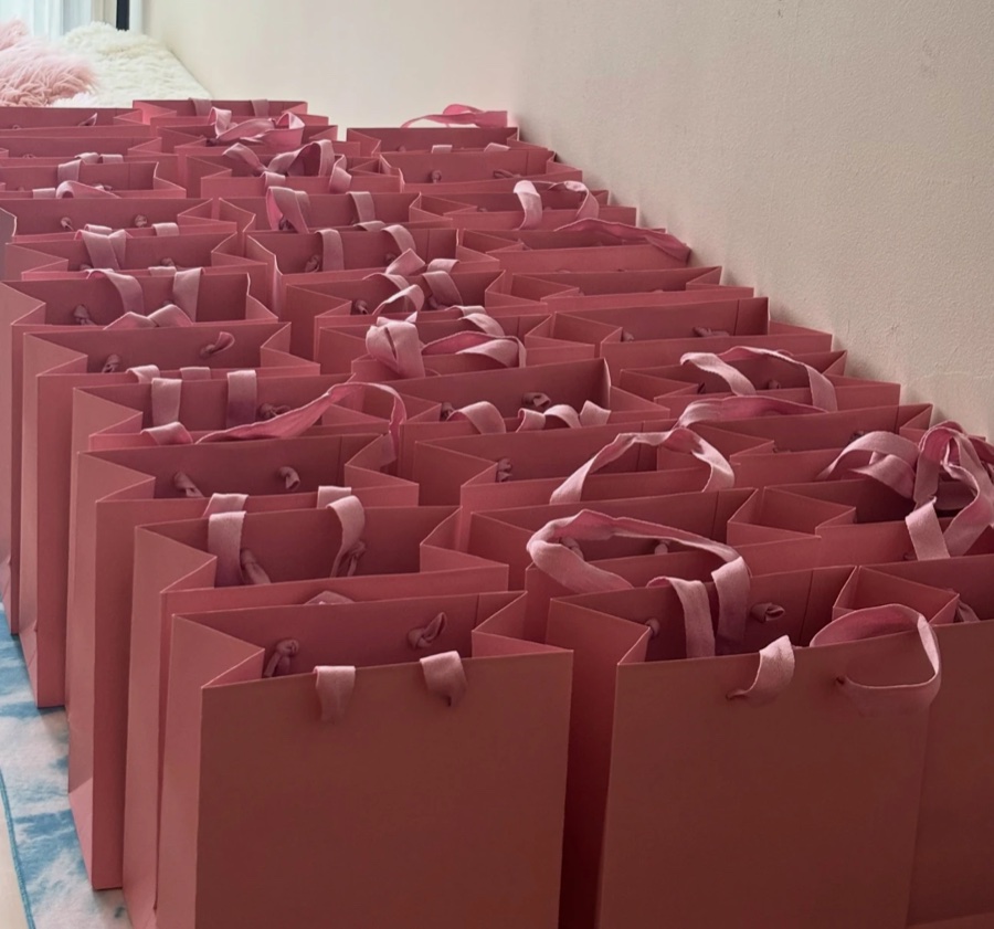 Rows of pink Matcha-chan gift bags ready for an event